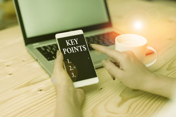 Conceptual hand writing showing Key Points. Concept meaning most important piece of information that is said or written woman with laptop smartphone and office supplies technology