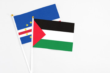Palestine and Cape Verde stick flags on white background. High quality fabric, miniature national flag. Peaceful global concept.White floor for copy space.