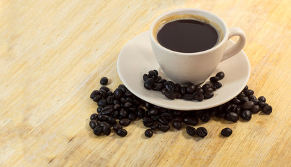 cup of coffee and beans on wooden table