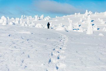Man hiking in the mountains on snowshoes in snow winter Finland.