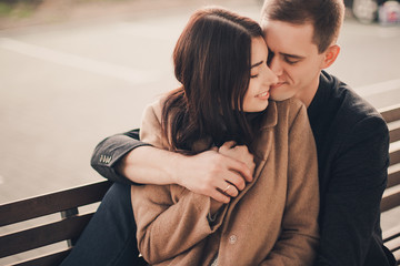 Loving couple hug sitting on the street.