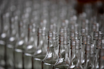 Glassworks. Glass industry. Many glass bottles on a factory conveyor.