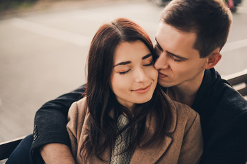 Loving couple hug sitting on the street.