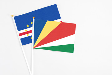 Seychelles and Cape Verde stick flags on white background. High quality fabric, miniature national flag. Peaceful global concept.White floor for copy space.