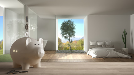 Wooden table top or shelf with white piggy bank with coins, modern panoramic bedroom with window and bed, expensive home interior design, renovation restructuring concept architecture