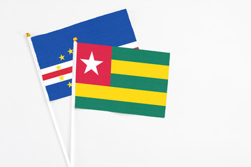 Togo and Cape Verde stick flags on white background. High quality fabric, miniature national flag. Peaceful global concept.White floor for copy space.