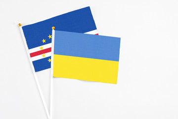 Ukraine and Cape Verde stick flags on white background. High quality fabric, miniature national flag. Peaceful global concept.White floor for copy space.