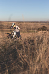 Tired little girl with bike goes uphill