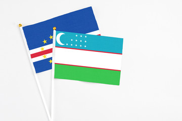 Uzbekistan and Cape Verde stick flags on white background. High quality fabric, miniature national flag. Peaceful global concept.White floor for copy space.