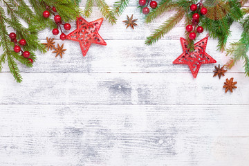 Christmas background with fir tree, holly and decoration on wooden table. Light bokeh. Top view...