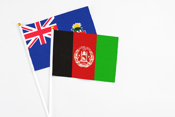 Afghanistan and Cayman Islands stick flags on white background. High quality fabric, miniature...