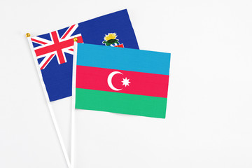 Azerbaijan and Cayman Islands stick flags on white background. High quality fabric, miniature national flag. Peaceful global concept.White floor for copy space.