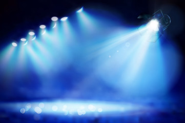 Stage during the show illuminated by spotlights. Blue background. Vector illustration.