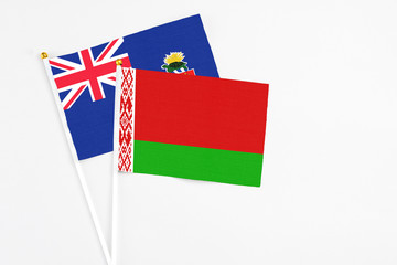 Belarus and Cayman Islands stick flags on white background. High quality fabric, miniature national flag. Peaceful global concept.White floor for copy space.