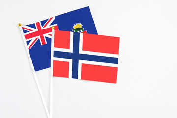 Bouvet Islands and Cayman Islands stick flags on white background. High quality fabric, miniature...