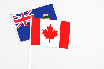 Canada and Cayman Islands stick flags on white background. High quality fabric, miniature national flag. Peaceful global concept.White floor for copy space.