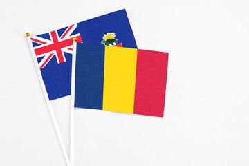 Chad and Cayman Islands stick flags on white background. High quality fabric, miniature national flag. Peaceful global concept.White floor for copy space.