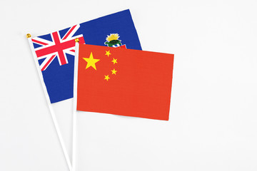 China and Cayman Islands stick flags on white background. High quality fabric, miniature national flag. Peaceful global concept.White floor for copy space.