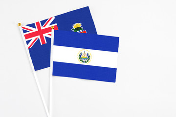 El Salvador and Cayman Islands stick flags on white background. High quality fabric, miniature...