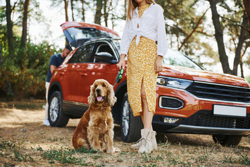 Couple with dog have weekend outdoors in the forest with car