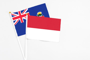 Indonesia and Cayman Islands stick flags on white background. High quality fabric, miniature national flag. Peaceful global concept.White floor for copy space.