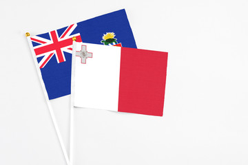 Malta and Cayman Islands stick flags on white background. High quality fabric, miniature national flag. Peaceful global concept.White floor for copy space.