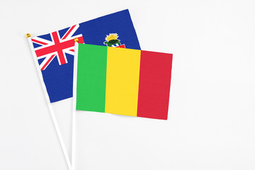 Mali and Cayman Islands stick flags on white background. High quality fabric, miniature national flag. Peaceful global concept.White floor for copy space.