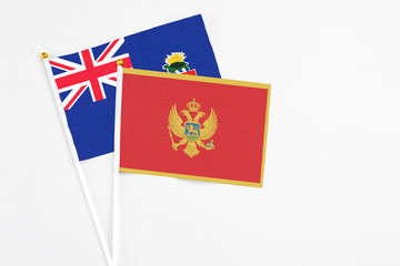 Montenegro and Cayman Islands stick flags on white background. High quality fabric, miniature national flag. Peaceful global concept.White floor for copy space.
