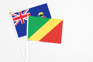 Republic Of The Congo and Cayman Islands stick flags on white background. High quality fabric, miniature national flag. Peaceful global concept.White floor for copy space.