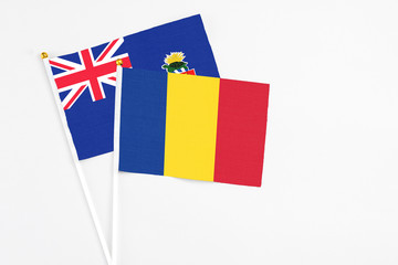 Romania and Cayman Islands stick flags on white background. High quality fabric, miniature national flag. Peaceful global concept.White floor for copy space.
