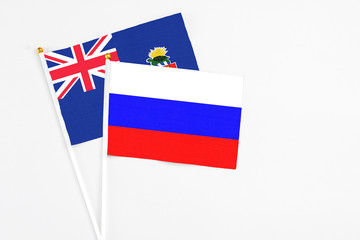 Russia and Cayman Islands stick flags on white background. High quality fabric, miniature national flag. Peaceful global concept.White floor for copy space.