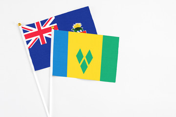 Saint Vincent And The Grenadines and Cayman Islands stick flags on white background. High quality fabric, miniature national flag. Peaceful global concept.White floor for copy space.