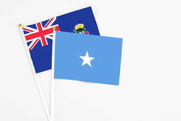 Somalia and Cayman Islands stick flags on white background. High quality fabric, miniature national flag. Peaceful global concept.White floor for copy space.