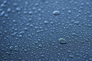 Macro photography of raindrop on water resistant metallic surface.