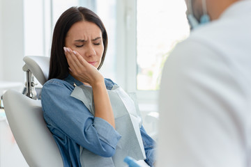 attractive woman with pain in dentist office with doctor