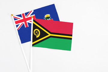 Vanuatu and Cayman Islands stick flags on white background. High quality fabric, miniature national flag. Peaceful global concept.White floor for copy space.