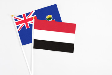 Yemen and Cayman Islands stick flags on white background. High quality fabric, miniature national flag. Peaceful global concept.White floor for copy space.
