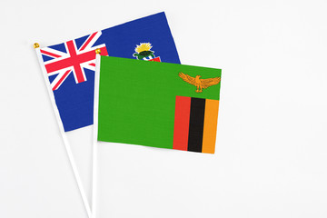 Zambia and Cayman Islands stick flags on white background. High quality fabric, miniature national flag. Peaceful global concept.White floor for copy space.