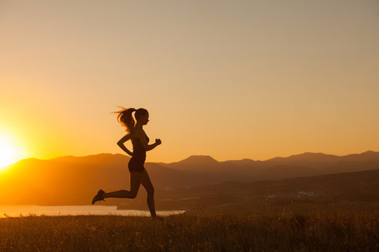 The girl runs in the mountains on the ocean.