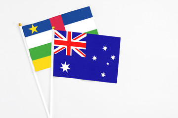 Fototapeta premium Australia and Central African Republic stick flags on white background. High quality fabric, miniature national flag. Peaceful global concept.White floor for copy space.