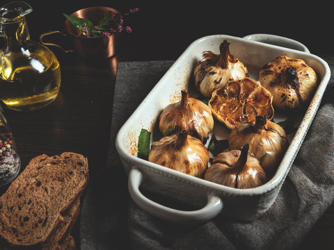 Fresh garlic roasting in olive oil. Close up. Rustic still life