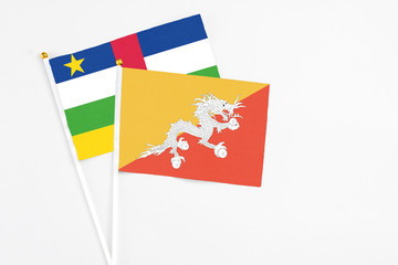 Bhutan and Central African Republic stick flags on white background. High quality fabric, miniature national flag. Peaceful global concept.White floor for copy space.