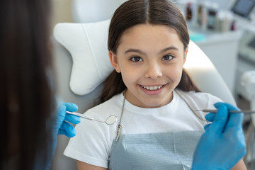 female doctor examining teeth of girl in the hospital