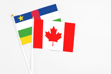 Canada and Central African Republic stick flags on white background. High quality fabric, miniature national flag. Peaceful global concept.White floor for copy space.