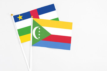 Comoros and Central African Republic stick flags on white background. High quality fabric, miniature national flag. Peaceful global concept.White floor for copy space.