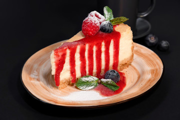 Delicious strawberry cheesecake slice and fresh berries on table close up