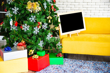 Christmas and New Year holiday concept. Christmas trees decoration with black board ribbons balls snowflakes and ornaments and gift boxes over white brick wall prepare for night party