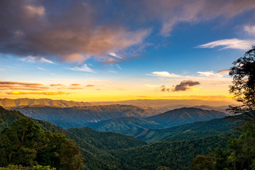 Fototapeta na wymiar Beautiful Landscape of mountain layer in morning sun ray and green forest.The sunrise shines down the green forest mountain in Thailand.