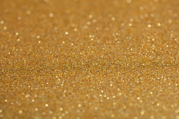 Background golden sparkles with bokeh.Gilded paper for background