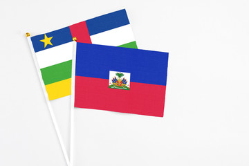 Haiti and Central African Republic stick flags on white background. High quality fabric, miniature national flag. Peaceful global concept.White floor for copy space.